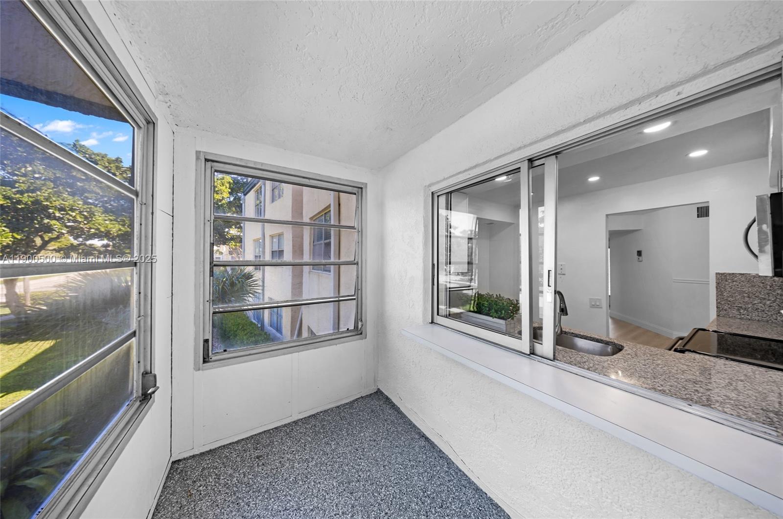 9090 Lime Bay Boulevard, Unit 211 Tamarac, FL 33321 - Photo 22 of 23 a view of an entryway with wooden floor and windows