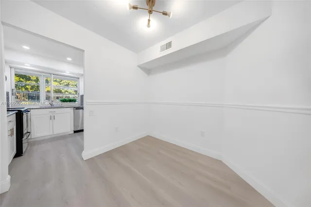 an empty room with a window and wooden floor