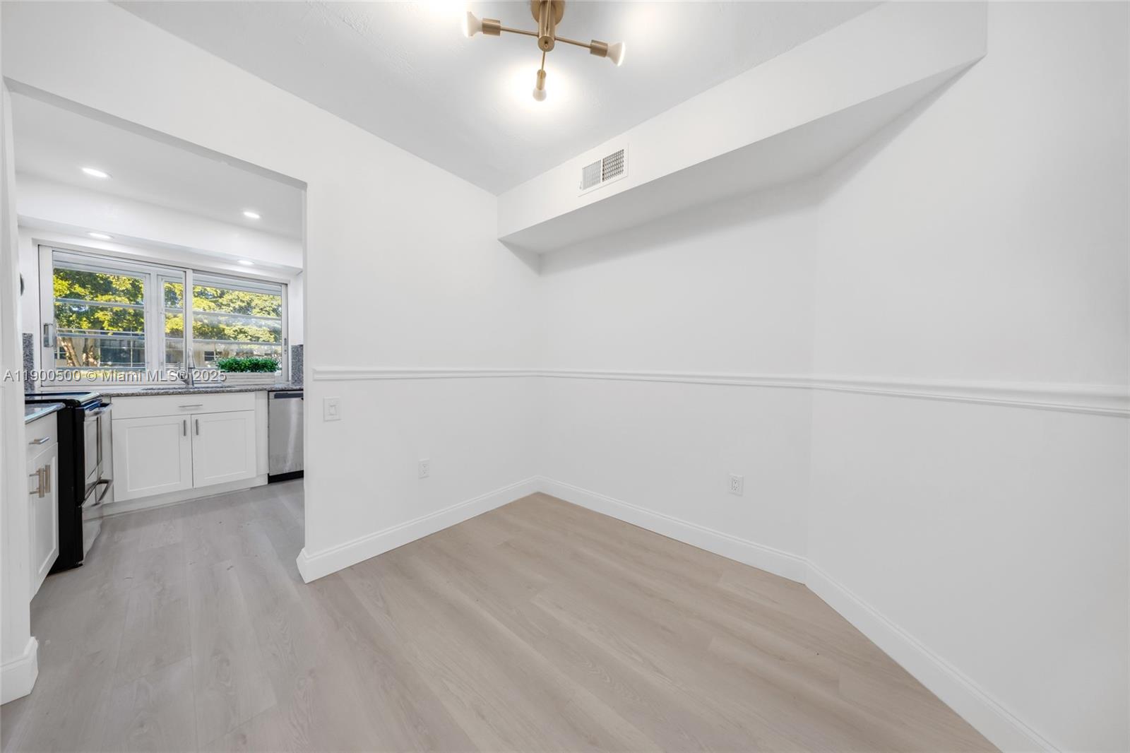 9090 Lime Bay Boulevard, Unit 211 Tamarac, FL 33321 - Photo 10 of 23 an empty room with a window and wooden floor