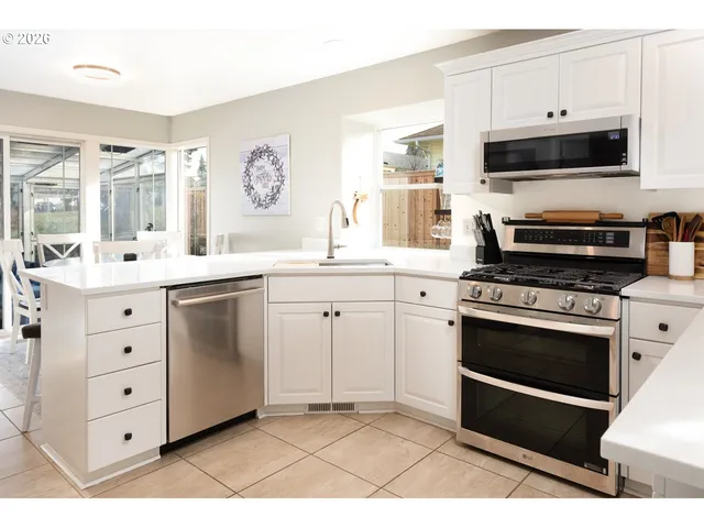 a kitchen with stainless steel appliances a stove a sink and a microwave
