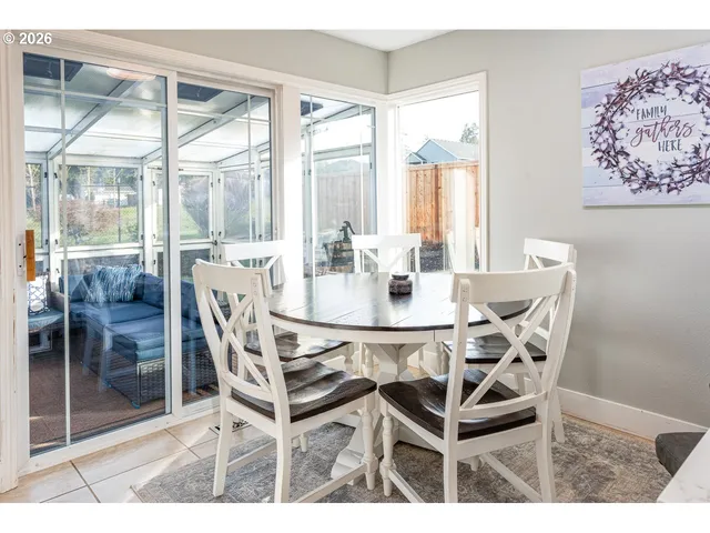 a dining room with furniture and large windows