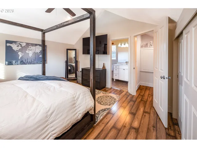 a bedroom with a bed and a large mirror on the dresser