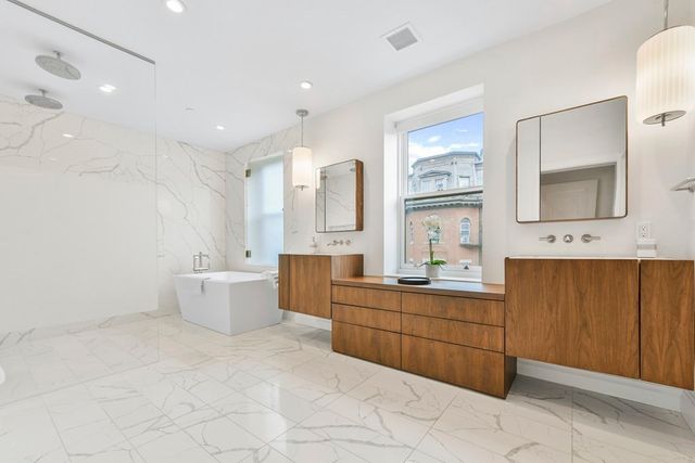a large bathroom with a large tub sink shower and mirror