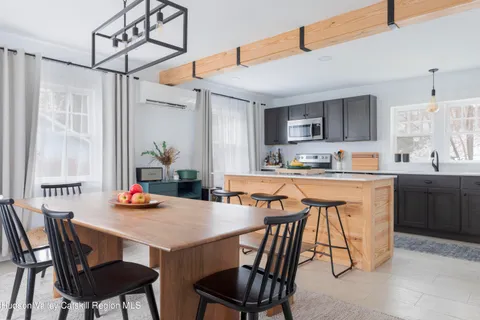 a dining room with stainless steel appliances a table and chairs