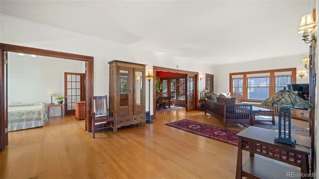 a living room with furniture a flat screen tv and floor to ceiling window