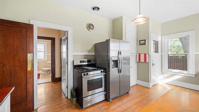 a kitchen with a refrigerator and a stove top oven