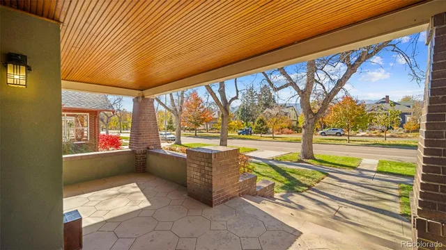 a living room with furniture a lamp wooden floor and windows