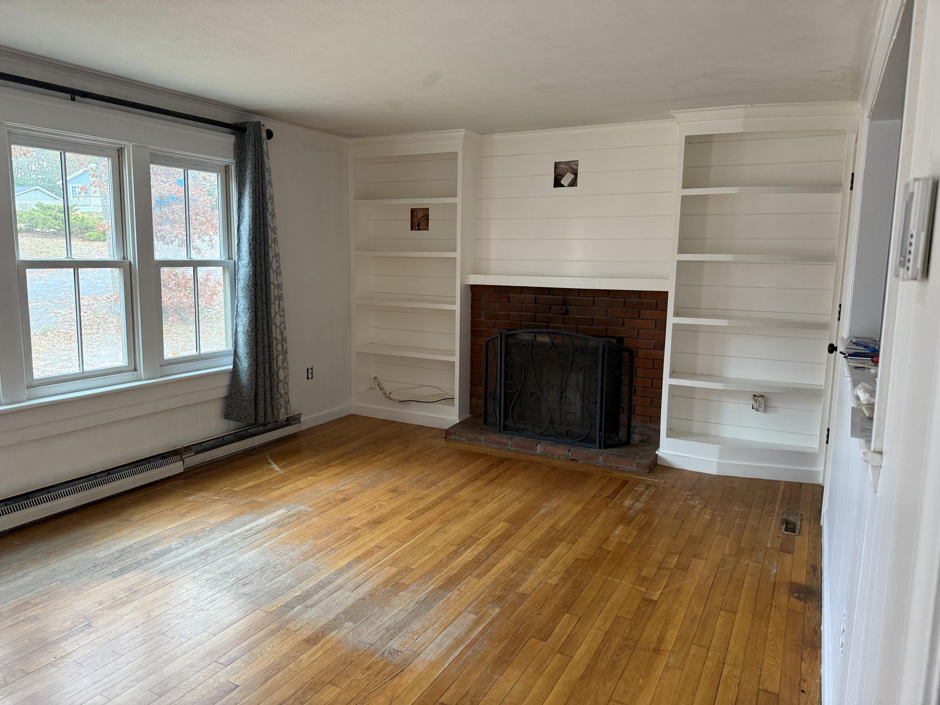 5 Huckleberry Lane Marstons Mills, MA 02648 - Photo 5 of 14 wooden floor fireplace and windows in an empty room