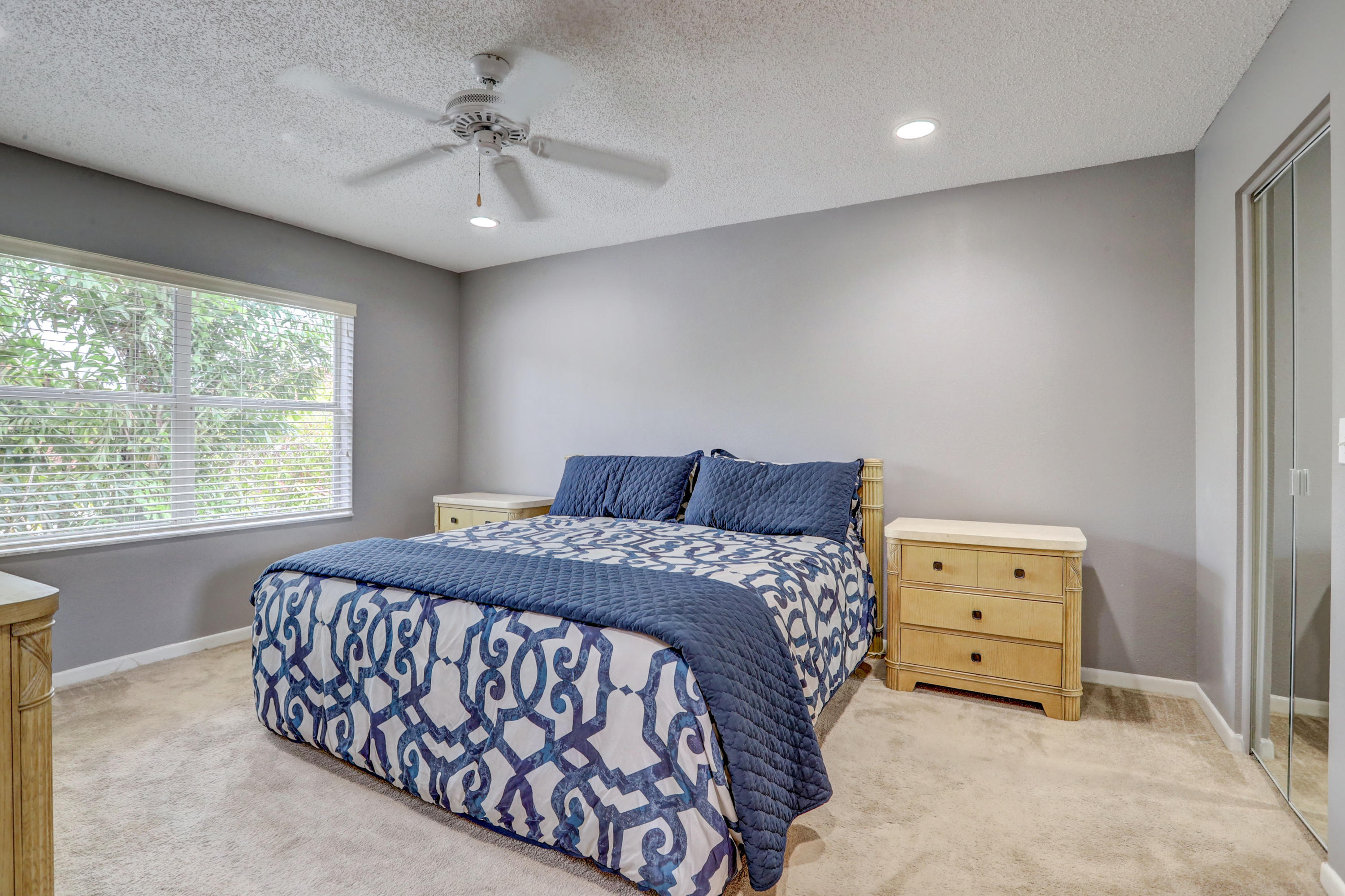 10620 Lake Jasmine Drive Boca Raton, FL 33498 - Photo 17 of 41 a bedroom with a bed and a chandelier