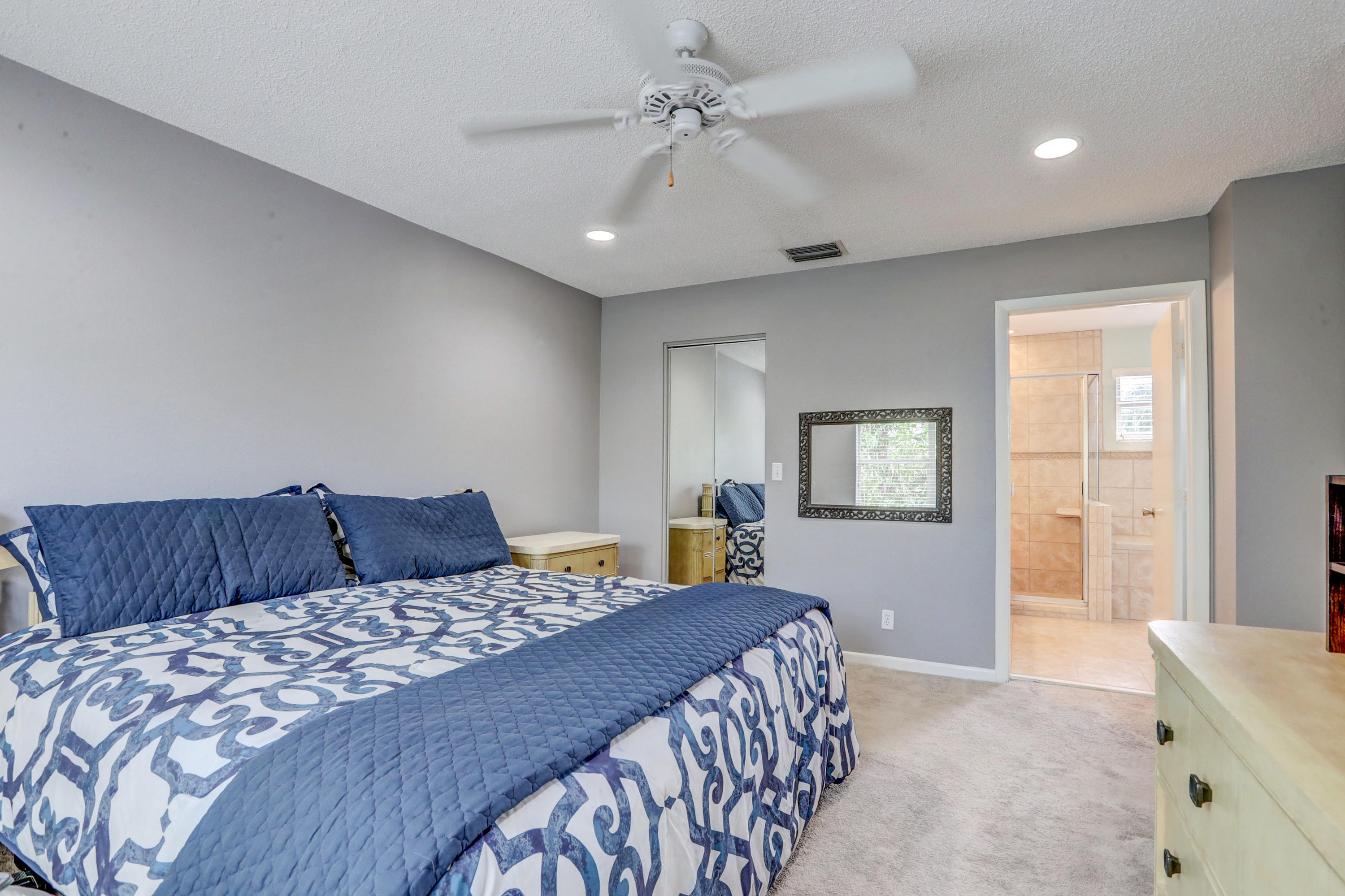 10620 Lake Jasmine Drive Boca Raton, FL 33498 - Photo 18 of 41 a bedroom with a large bed and a chandelier