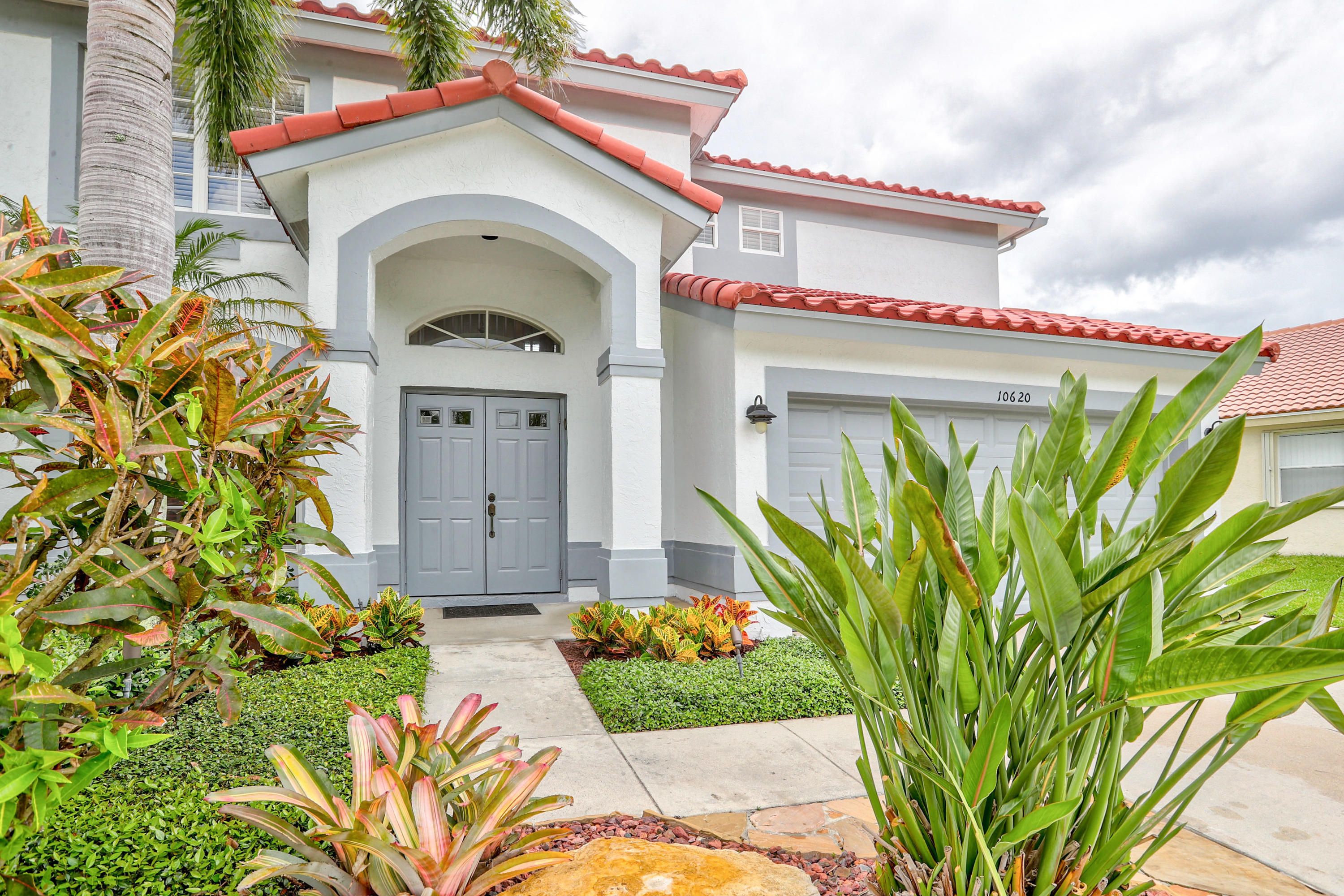 10620 Lake Jasmine Drive Boca Raton, FL 33498 - Photo 3 of 41 a front view of a house with a garden