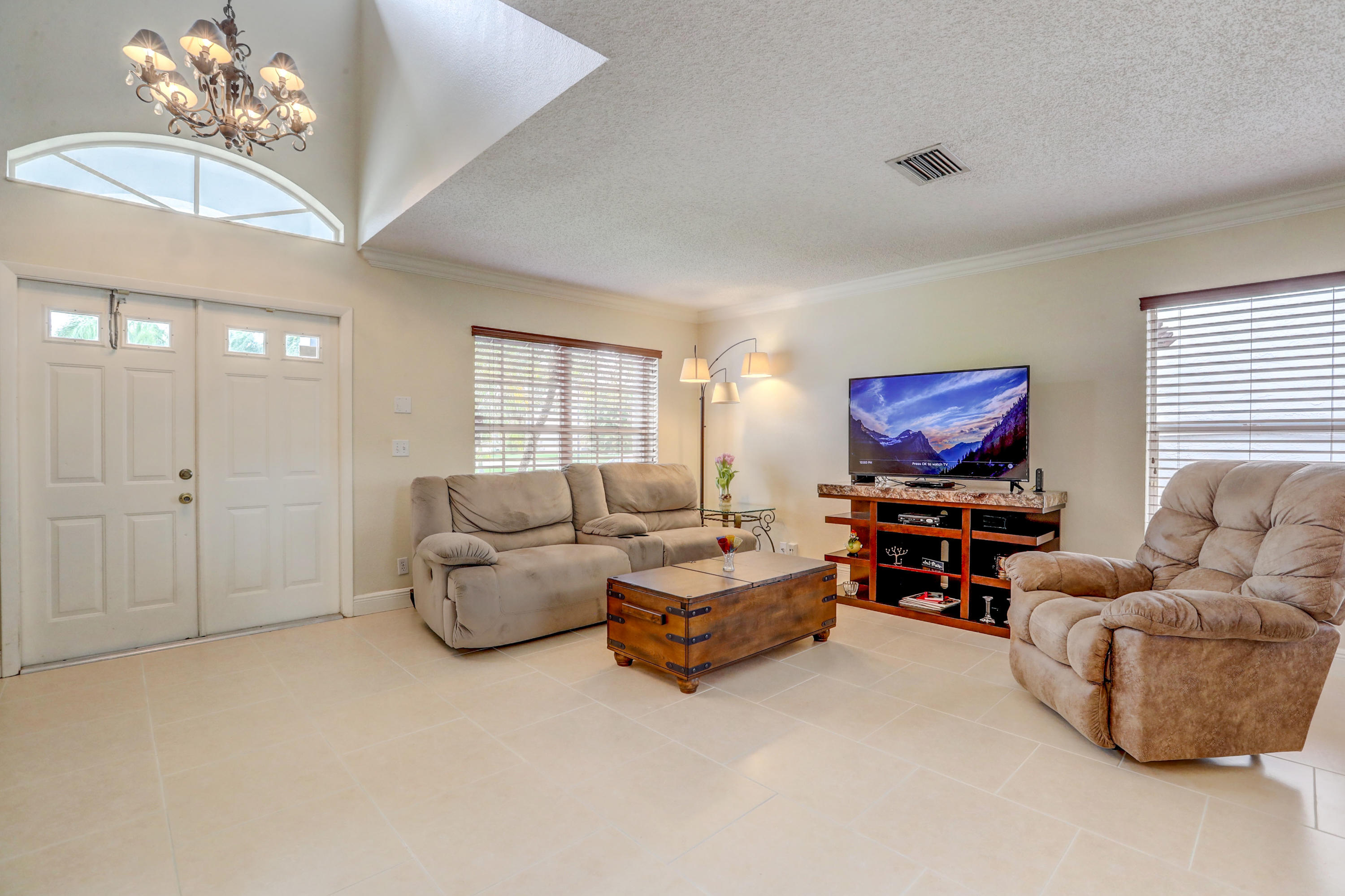 10620 Lake Jasmine Drive Boca Raton, FL 33498 - Photo 5 of 41 a living room with furniture and a flat screen tv