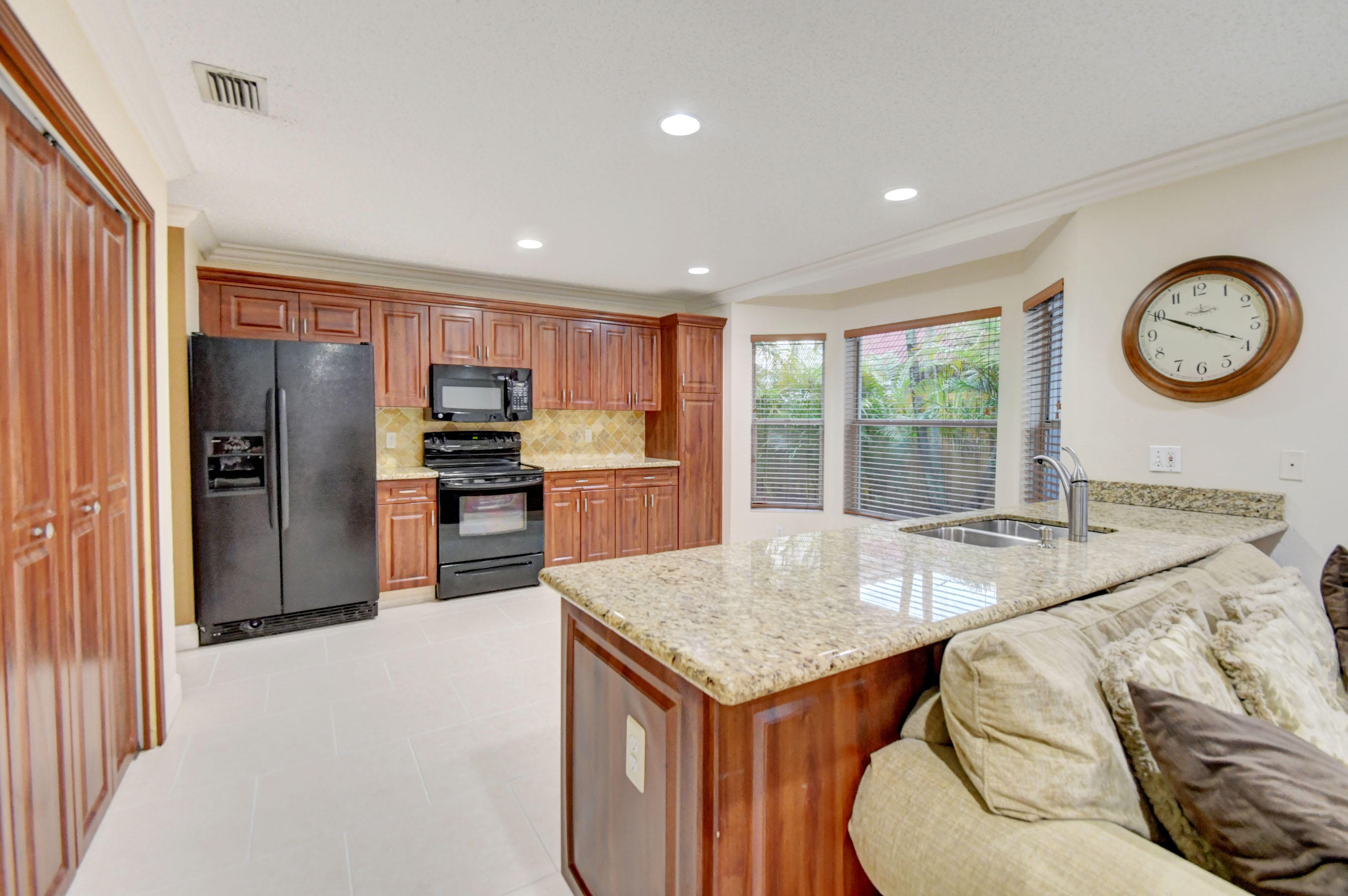 10620 Lake Jasmine Drive Boca Raton, FL 33498 - Photo 10 of 41 a kitchen with granite countertop a refrigerator a stove a sink a dining table and chairs