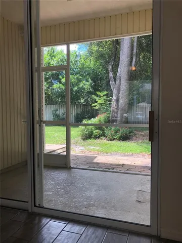 a view of a porch with a floor to ceiling window and a yard
