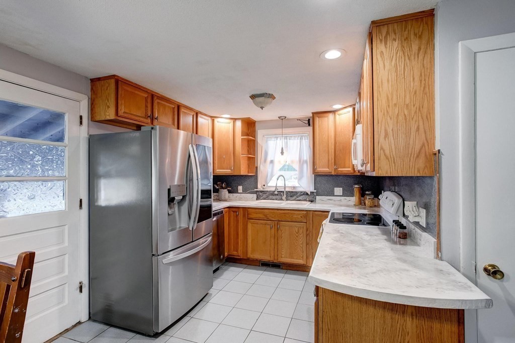 29 Basse Circle Lynn, MA 01905 - Photo 17 of 32 a kitchen with stainless steel appliances granite countertop a refrigerator a stove and a sink