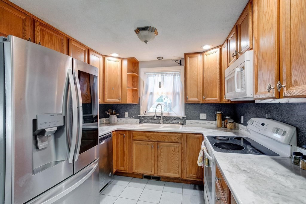 29 Basse Circle Lynn, MA 01905 - Photo 18 of 32 a kitchen with a sink a refrigerator and cabinets