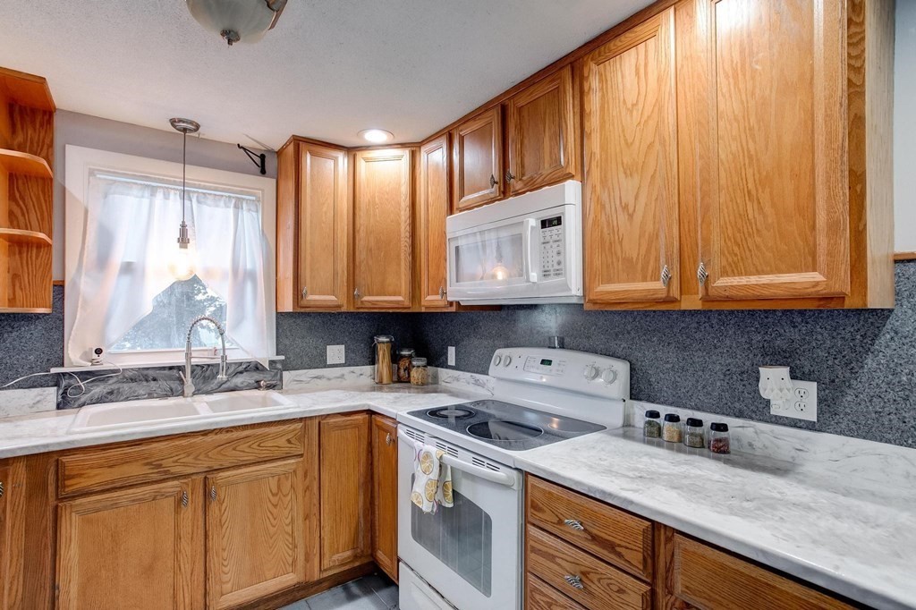 29 Basse Circle Lynn, MA 01905 - Photo 20 of 32 a kitchen with stainless steel appliances granite countertop a sink a stove and cabinets