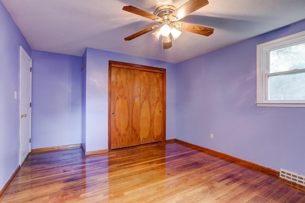 29 Basse Circle Lynn, MA 01905 - Photo 24 of 32 an empty room with wooden floor chandelier fan and windows