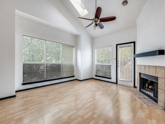a view of an empty room with a fireplace and a window