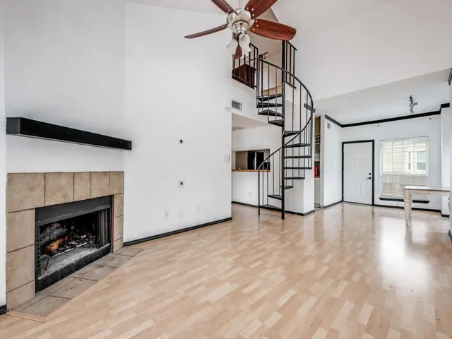 a view of a livingroom with wooden floor fireplace and stairs