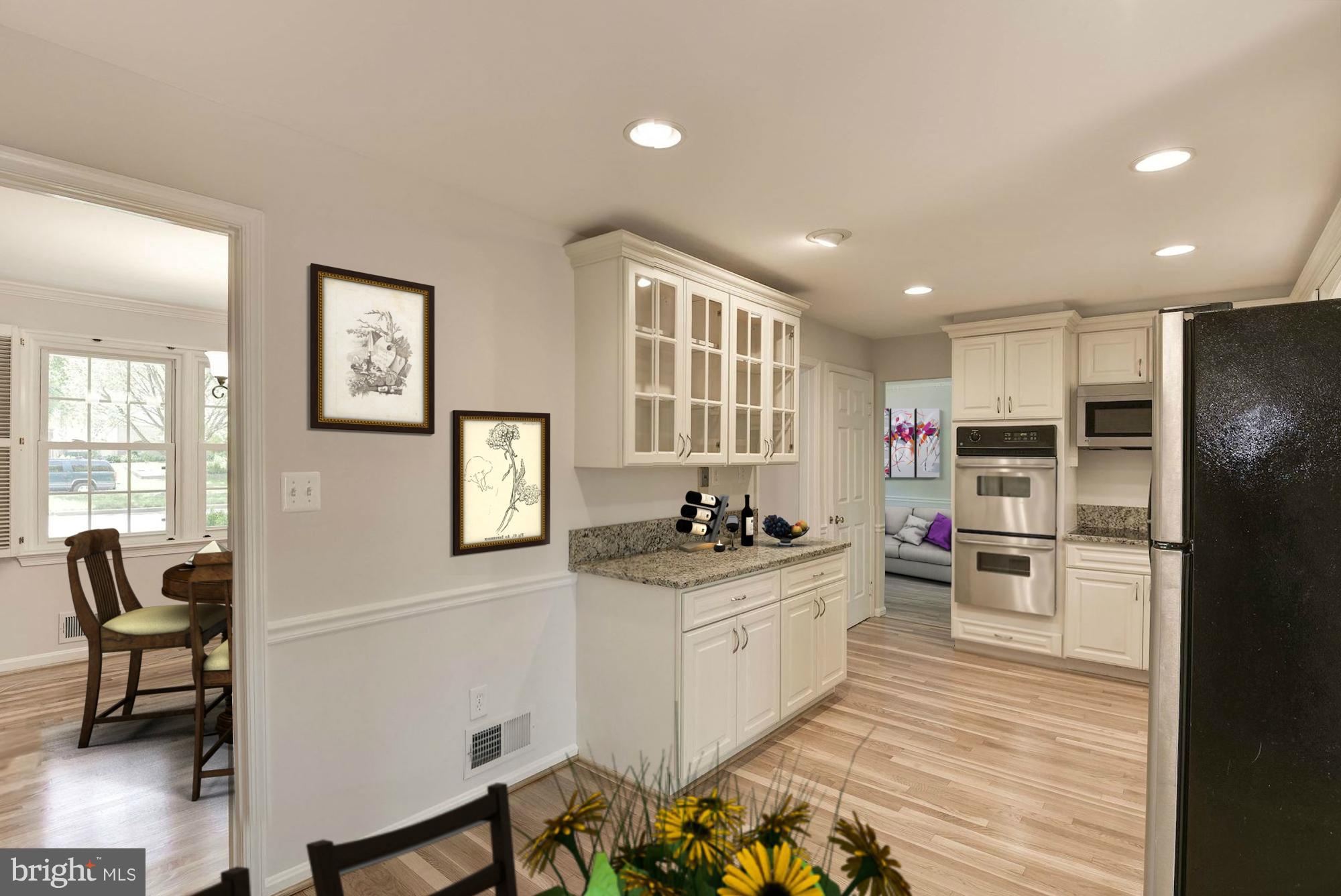 6732 Huntsman Boulevard Springfield, VA 22152 - Photo 4 of 23 a kitchen with stainless steel appliances kitchen island granite countertop a refrigerator oven a sink dishwasher and white cabinets with wooden floor