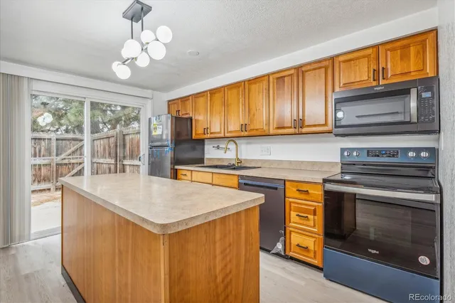 a kitchen with stainless steel appliances granite countertop a stove top oven a sink dishwasher and a microwave oven with cabinets