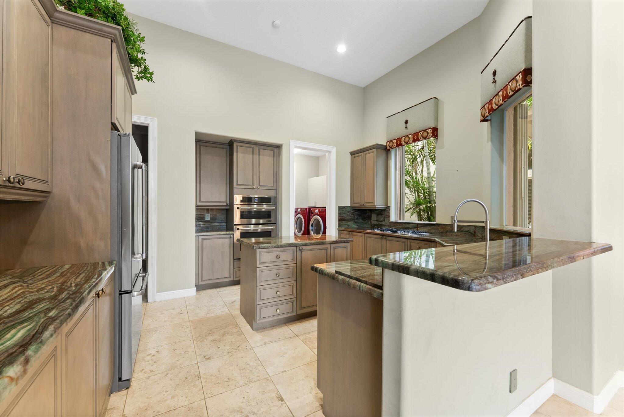 7081 Mallorca Crescent Boca Raton, FL 33433 - Photo 5 of 26 a kitchen with stainless steel appliances granite countertop a sink and a refrigerator