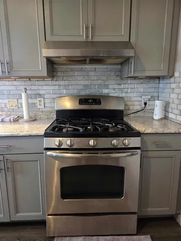 a stove top oven sitting inside of a kitchen and granite counter tops