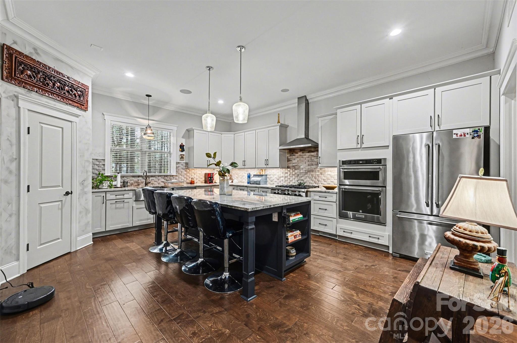 6302 Chimney Bluff Road Lancaster, SC 29720 - Photo 10 of 47 a kitchen with stainless steel appliances kitchen island granite countertop a table chairs and a refrigerator