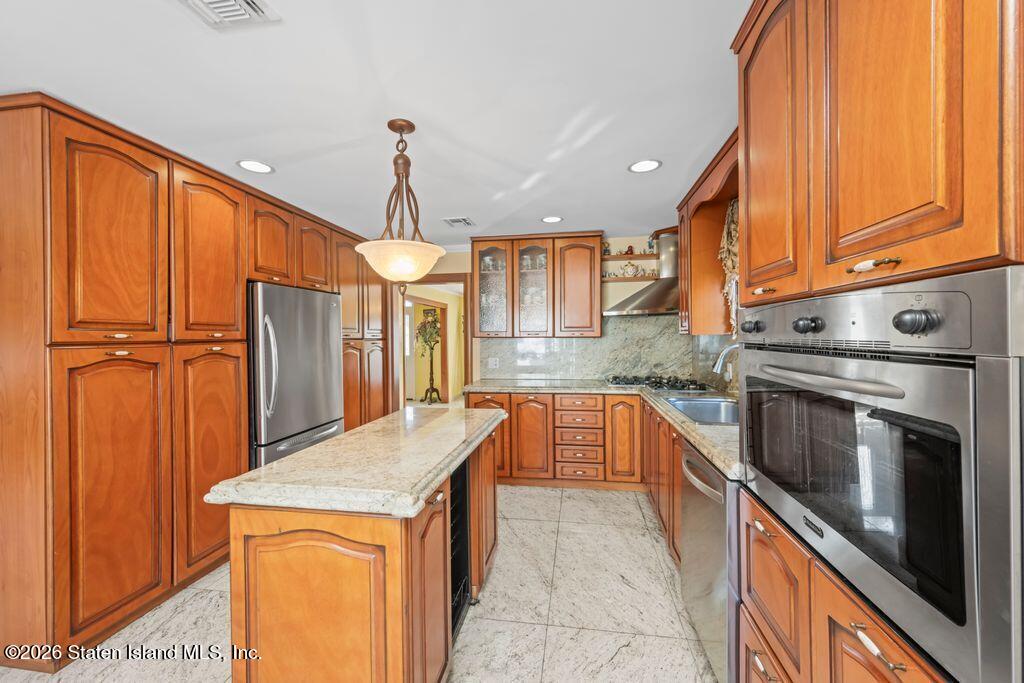5 Rigimar Court Staten Island, NY 10309 - Photo 11 of 37 a kitchen with granite countertop a sink stainless steel appliances wooden floor and cabinets