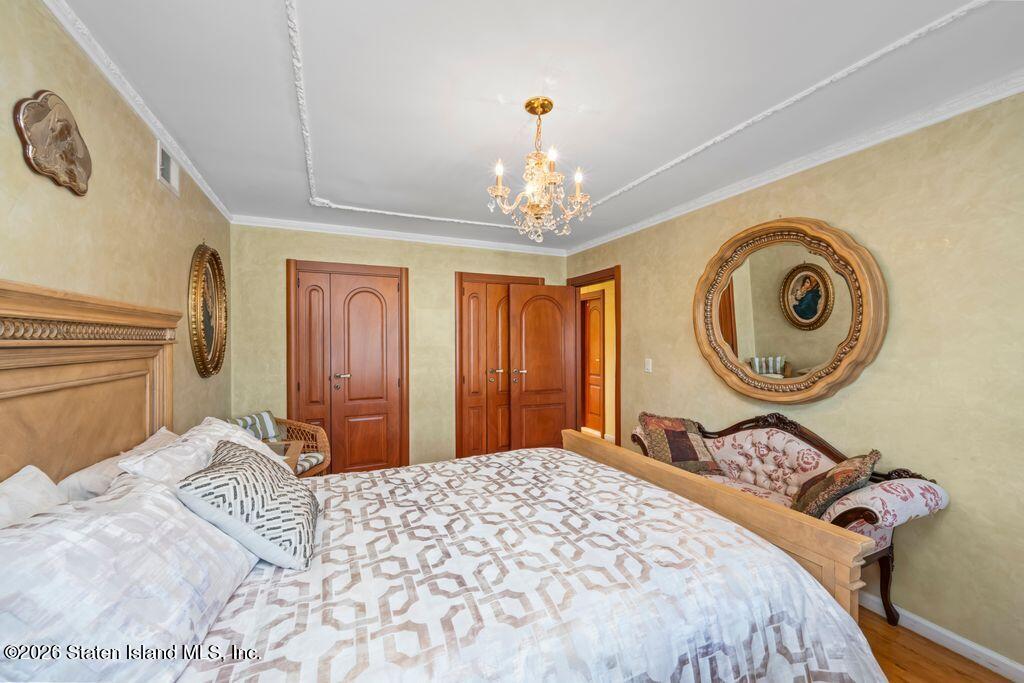 5 Rigimar Court Staten Island, NY 10309 - Photo 19 of 37 a bedroom with a bed and a chandelier