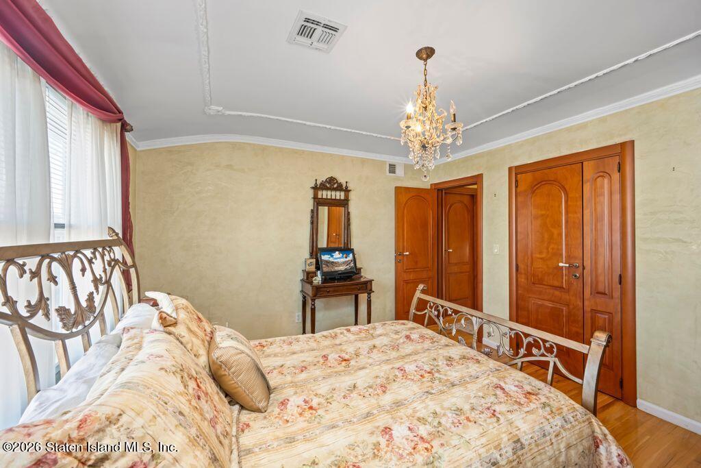 5 Rigimar Court Staten Island, NY 10309 - Photo 22 of 37 a bedroom with a large bed and a chandelier
