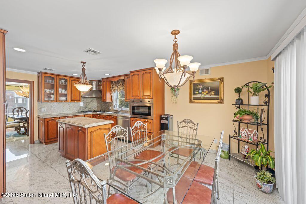 5 Rigimar Court Staten Island, NY 10309 - Photo 10 of 37 a view of a dining room with furniture a chandelier and wooden floor