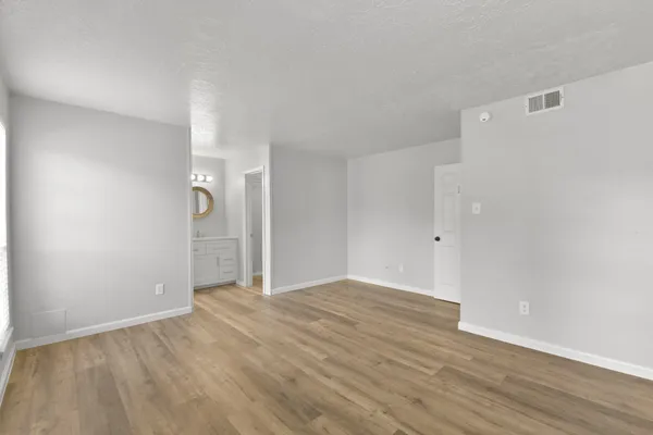 a view of an empty room with wooden floor