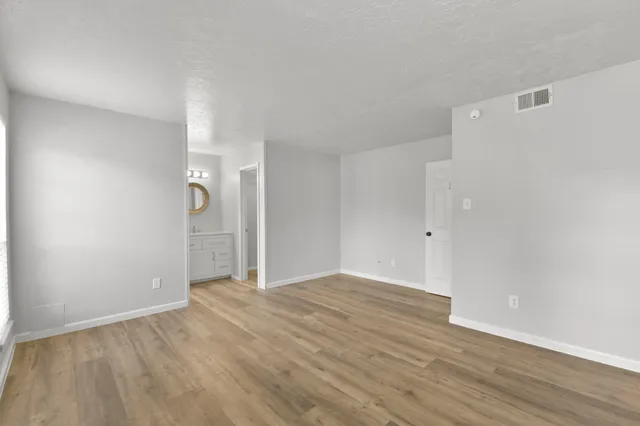 a view of an empty room with wooden floor