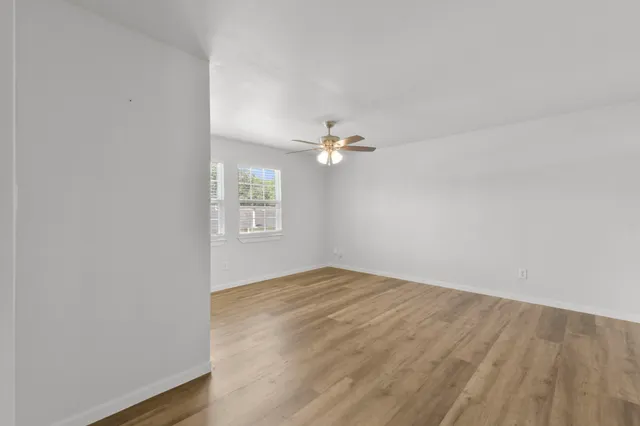 a view of empty room with wooden floor