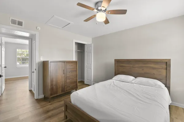 a bedroom with a large bed and wooden floor