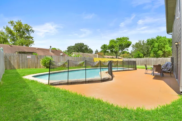 a view of a backyard with swimming pool