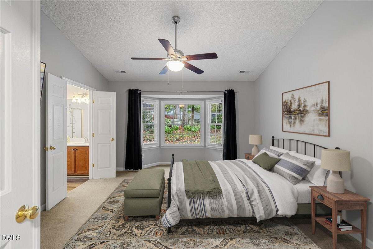 12436 Harcourt Drive Raleigh, NC 27613 - Photo 10 of 29 a spacious bedroom with a large bed and a chandelier