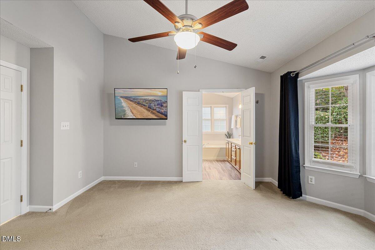 12436 Harcourt Drive Raleigh, NC 27613 - Photo 12 of 29 an empty room with chandelier fan and windows