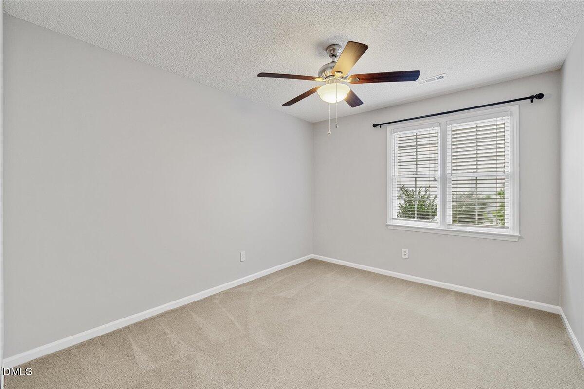 12436 Harcourt Drive Raleigh, NC 27613 - Photo 16 of 29 an empty room with windows and fan