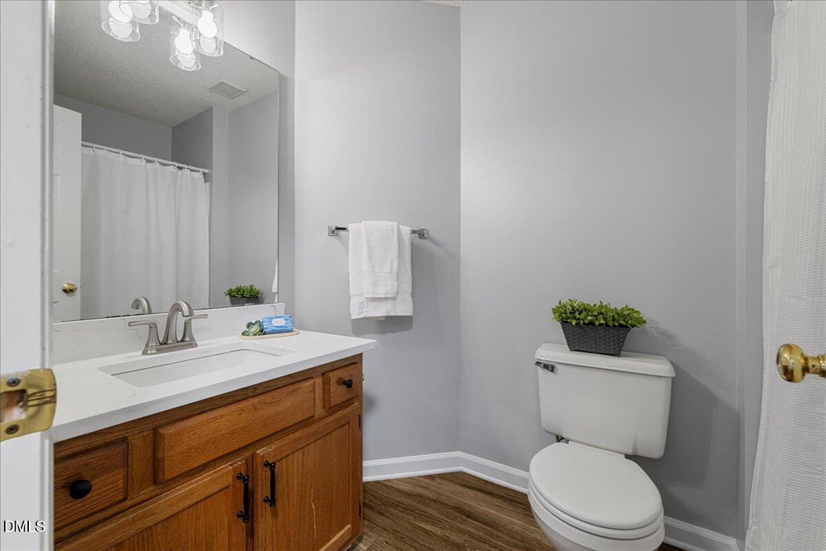 12436 Harcourt Drive Raleigh, NC 27613 - Photo 17 of 29 a bathroom with a granite countertop toilet sink and mirror