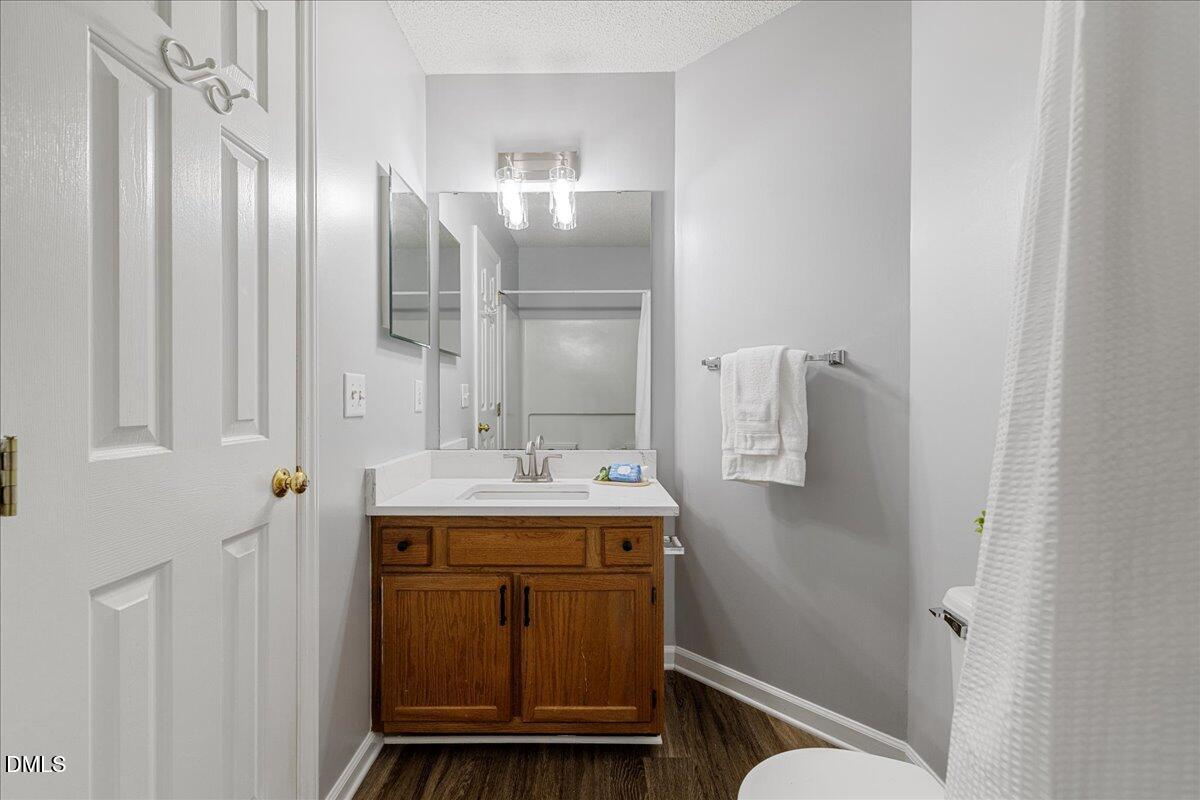 12436 Harcourt Drive Raleigh, NC 27613 - Photo 19 of 29 a bathroom with a granite countertop sink a toilet and shower