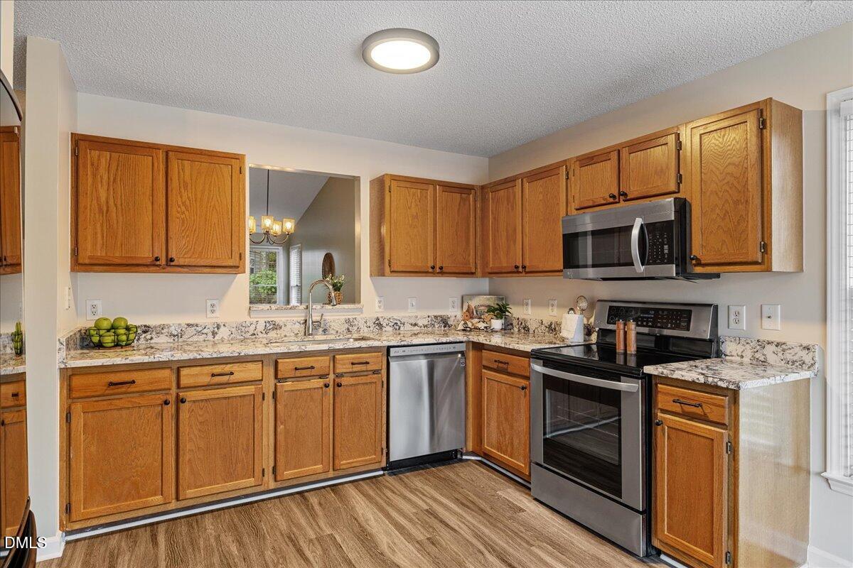 12436 Harcourt Drive Raleigh, NC 27613 - Photo 4 of 29 a kitchen with stainless steel appliances granite countertop a stove sink microwave and cabinets