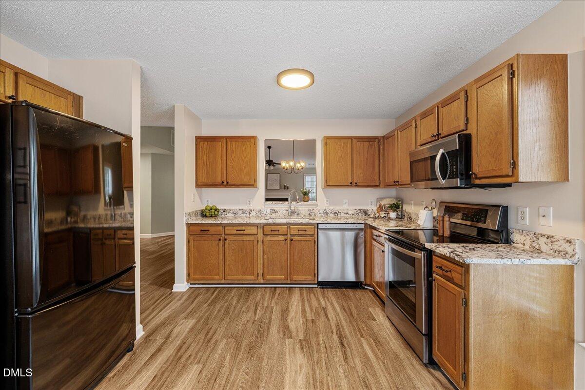 12436 Harcourt Drive Raleigh, NC 27613 - Photo 5 of 29 a kitchen with a sink wooden floor and stainless steel appliances