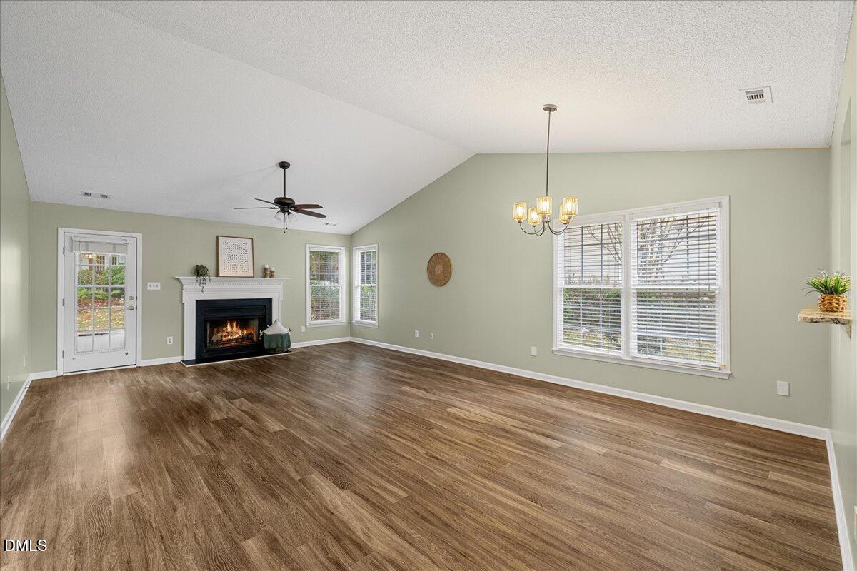 12436 Harcourt Drive Raleigh, NC 27613 - Photo 8 of 29 a view of an empty room with wooden floor fireplace and a window