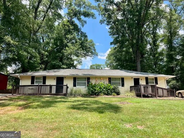 a view of a house with a yard deck and swimming pool