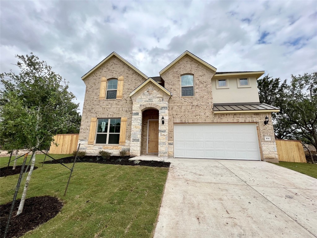 a front view of a house with a yard and garage