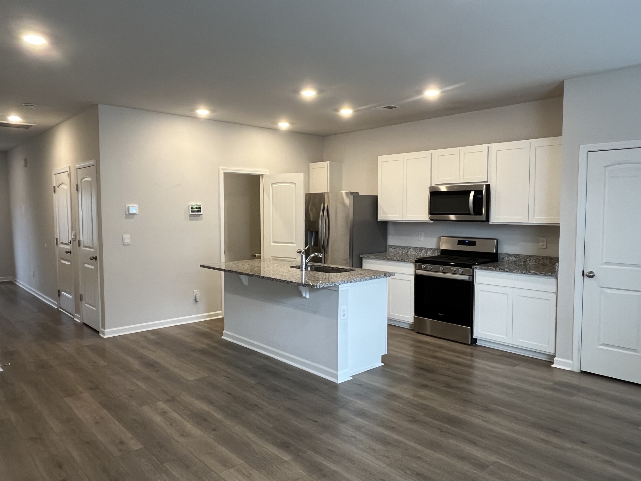 441 Waterfowl Way Lebanon, TN 37090 - Photo 3 of 21 a kitchen with kitchen island granite countertop a refrigerator and a stove top oven