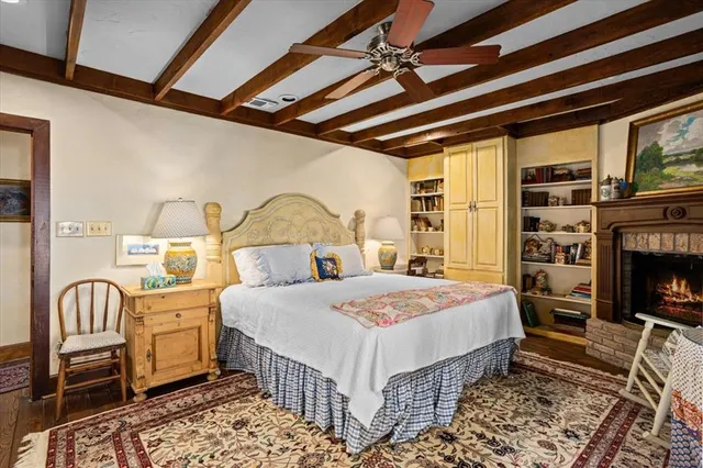 a bedroom with a bed a flat screen tv and a fireplace